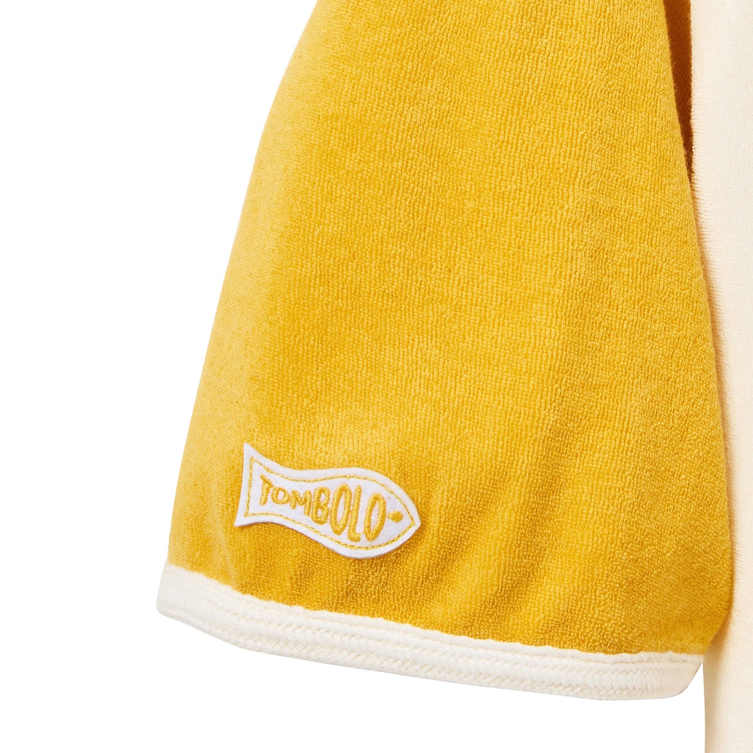 Yellow towel with a white border and 'Tombolo' logo on a white background