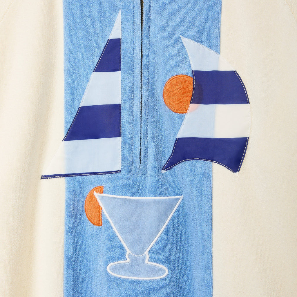 Light blue towel with sailboat and martini glass designs on a beige background