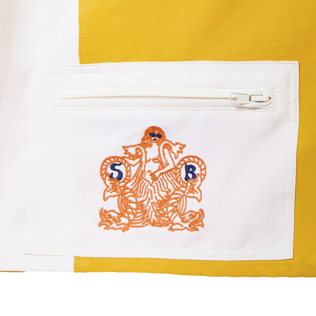 Embroidered Sunset Beach logo on a white pocket with yellow trim