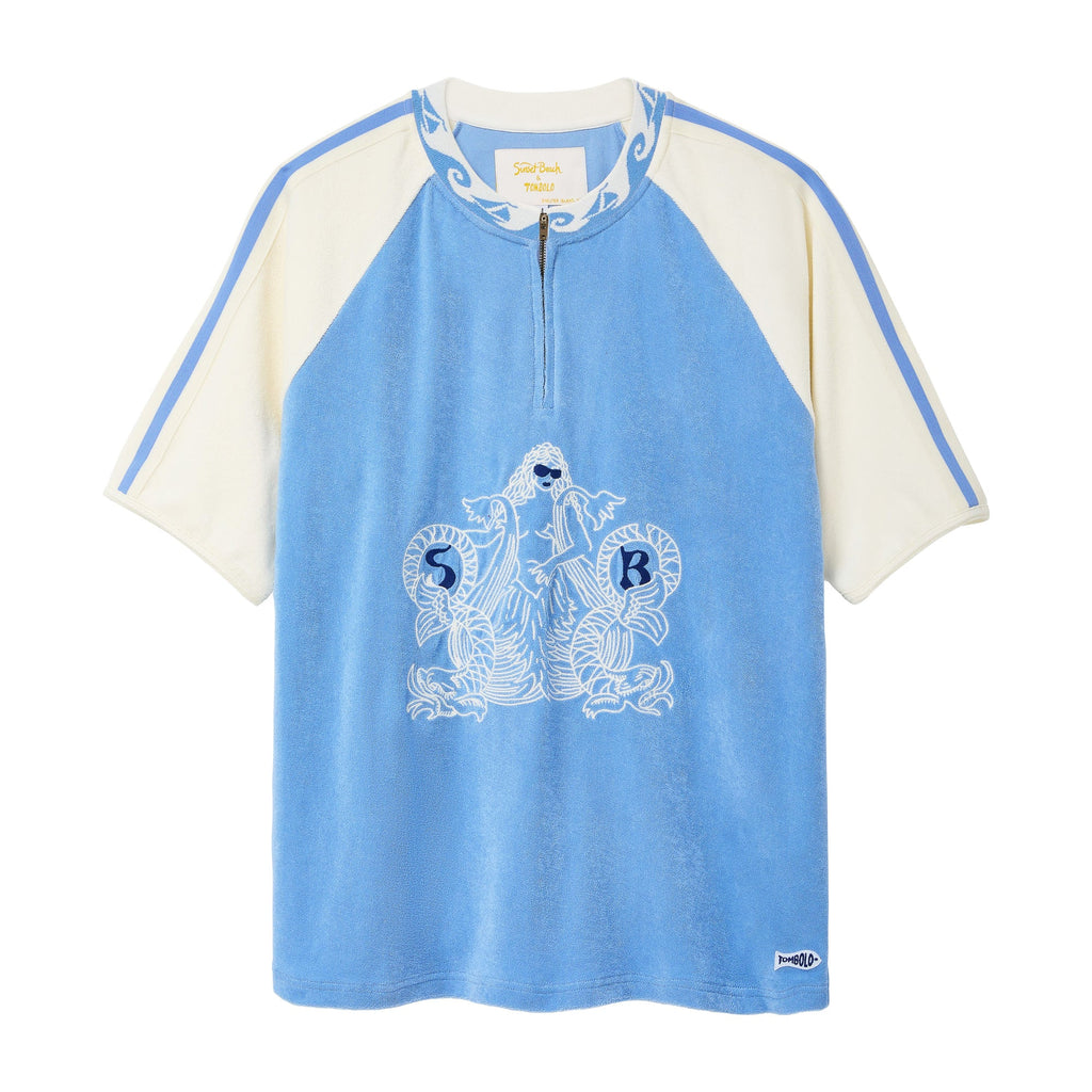 A light blue and cream raglan-style short-sleeve top with a half-zip neckline, featuring a white graphic print of a mermaid and the letters 'S B' on the front, set against a plain white background.